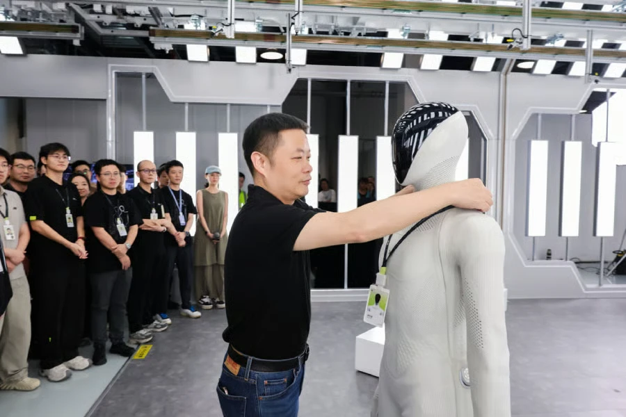 XPENG Chairman and CEO He Xiaopeng inspects the company’s IRON humanoid robot.